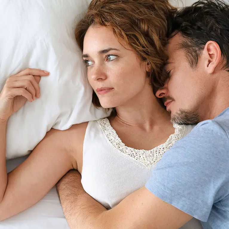 Paar liegt im Bett - Früherkennungsprogramm