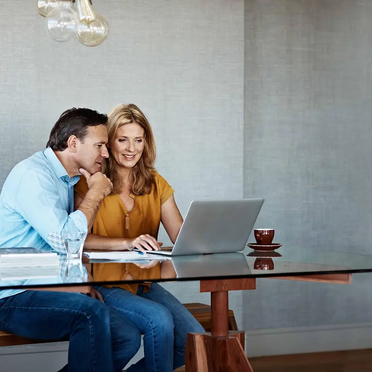 Mann und Frau sitzen am Laptop - Krebs-Scan
