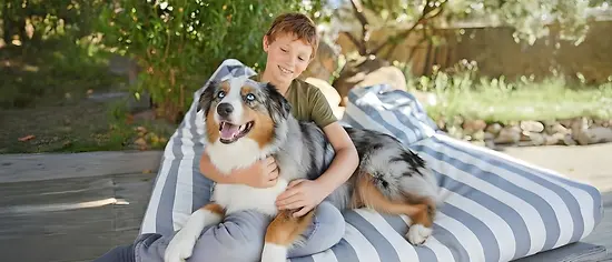 Kind kuschelt mit Hund - Hundekrankenversicherung