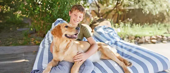 Kind kuschelt mit Hund - Hundekrankenversicherung