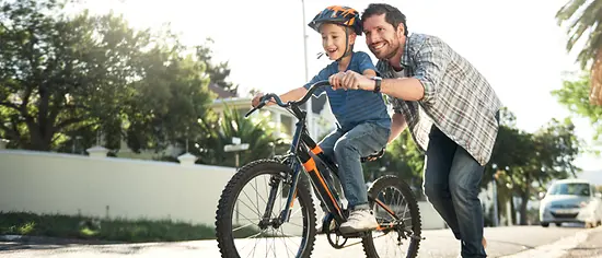 Unfallversicherung Kind: Kind auf Fahrrad mit Vater