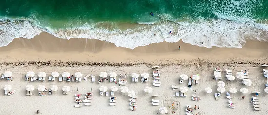 Packliste Sommerurlaub: Liegen und Sonnenschirme am Strand