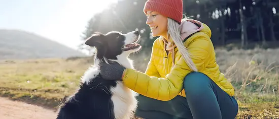 Frau und Hund sind spazieren - Hunde-OP-Versicherung