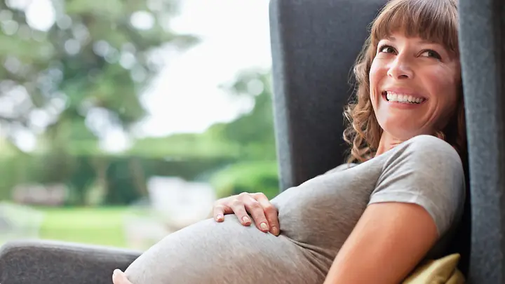 Schwangere Frau im Sessel