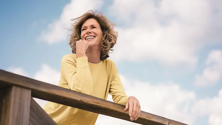 Frau mit gelben Pullover: Elvea Health - Hilfe in den Wechseljahren