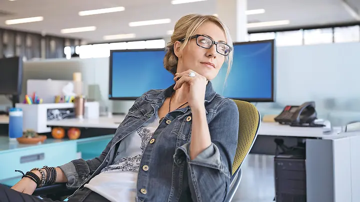 Frau sitzt im Büro - Private Rentenversicherung