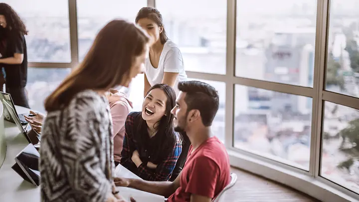 Lachende junge Leute - Reiseversicherung Schüler und Studenten