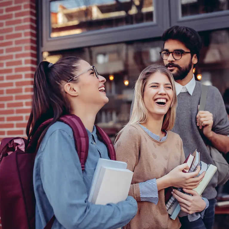 Drei junge Leute im Gespräch - Reiseversicherung Young Travel