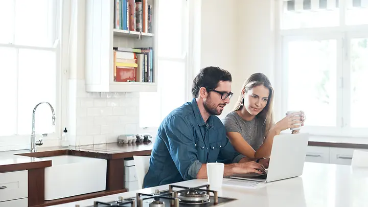 Mann und Frau schauen auf Laptop - Vergleich PKV und GKV