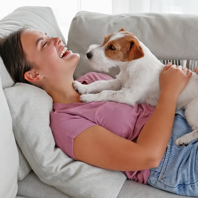 Frau chillt mit ihrem Hund zu Hause