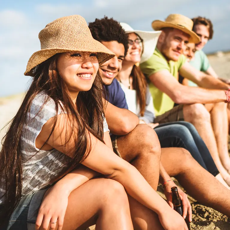 Sechs junge Leute am Strand - Reisegruppenversicherung