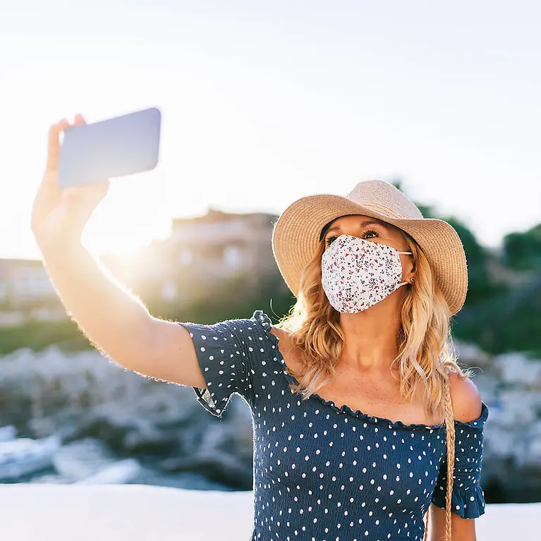 Frau mit Mundschutz fotografiert sich - Pandemie-Schutz Plus