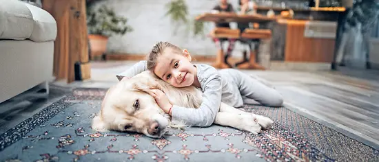 Kind umarmt Hund - Hundeversicherung